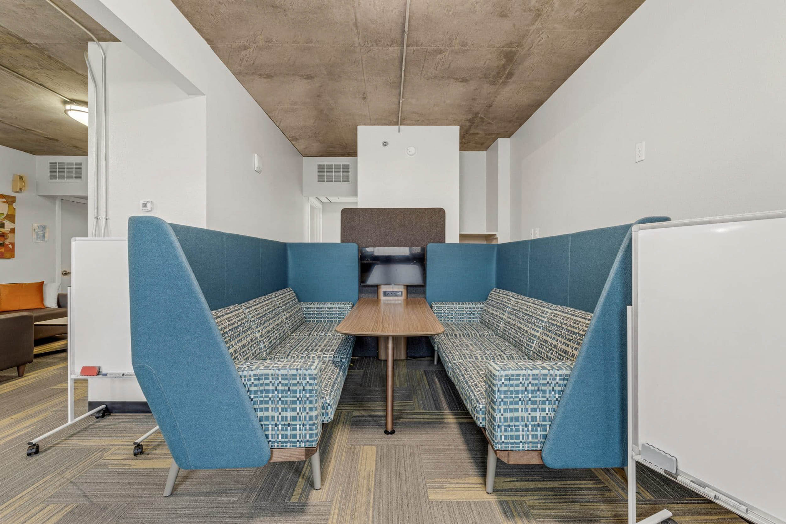 Coworking bench seating with outlets screen and whiteboard