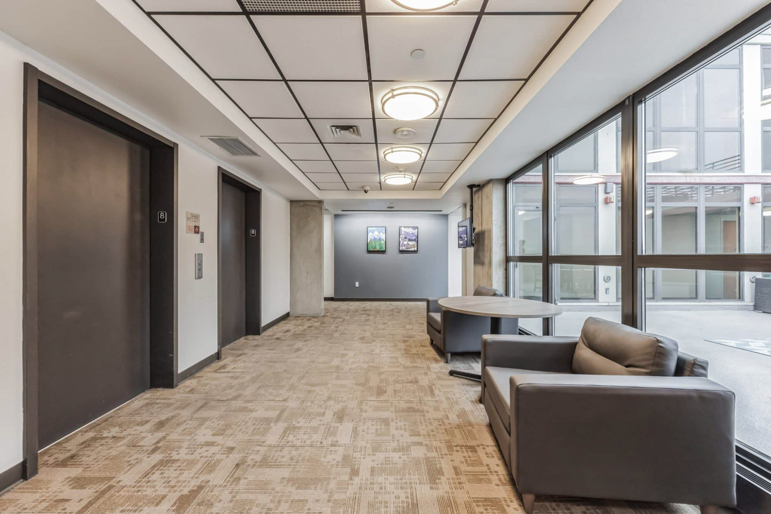 Elevator lobby area with large windows and seating