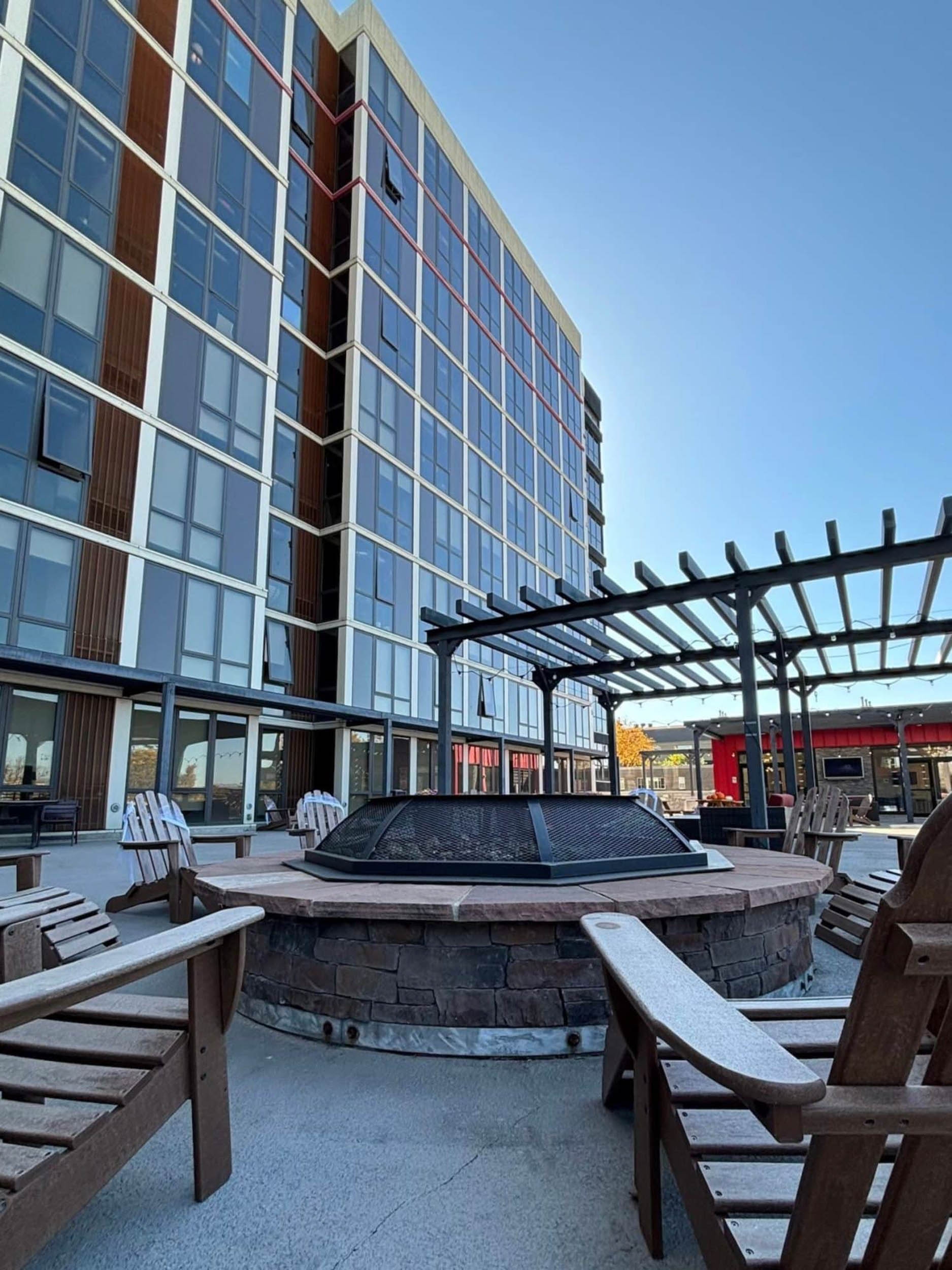 Outdoor courtyard with fire pits and pergola facing apartment building