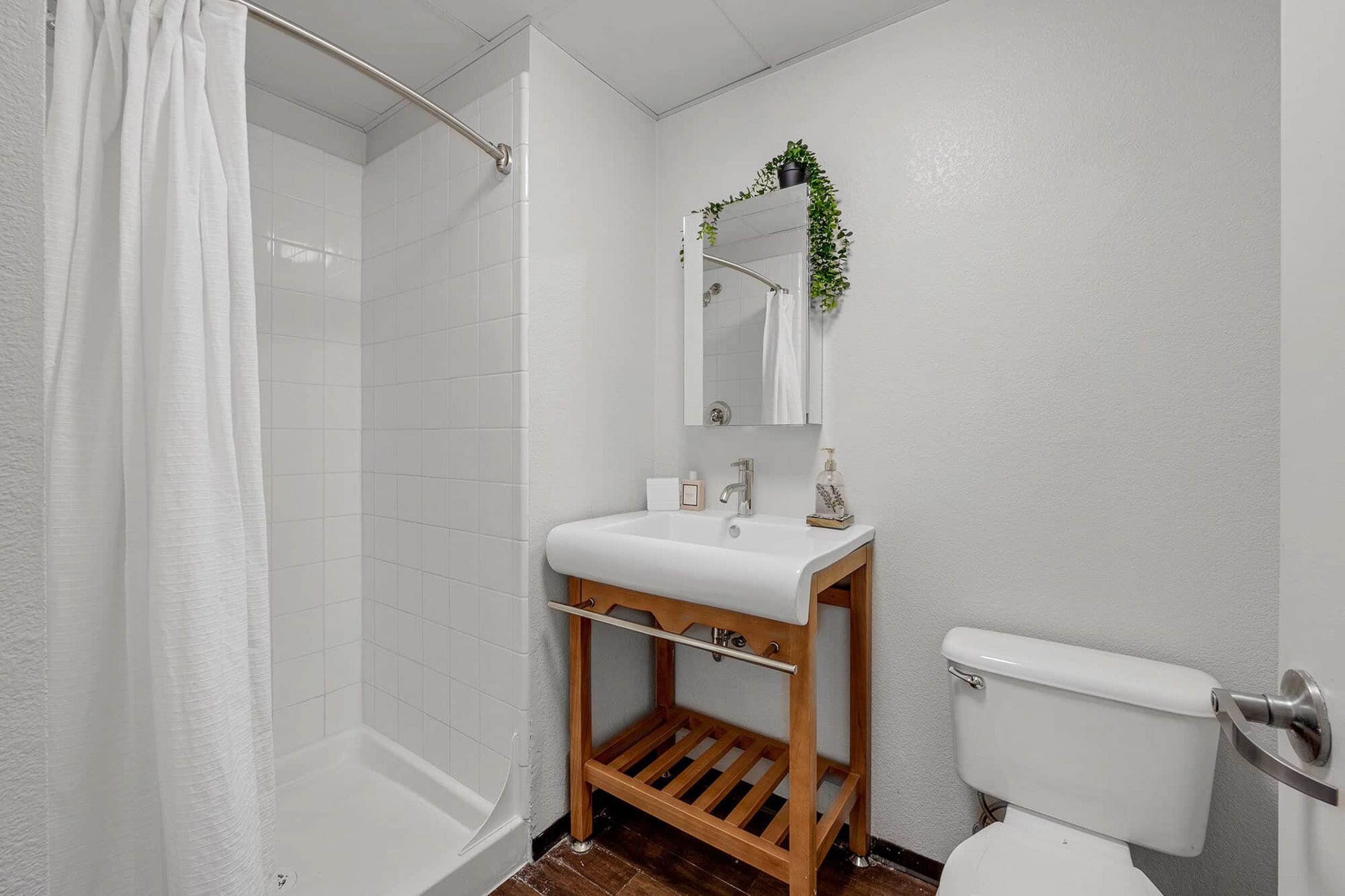 White bathroom with shower toilet and vanity